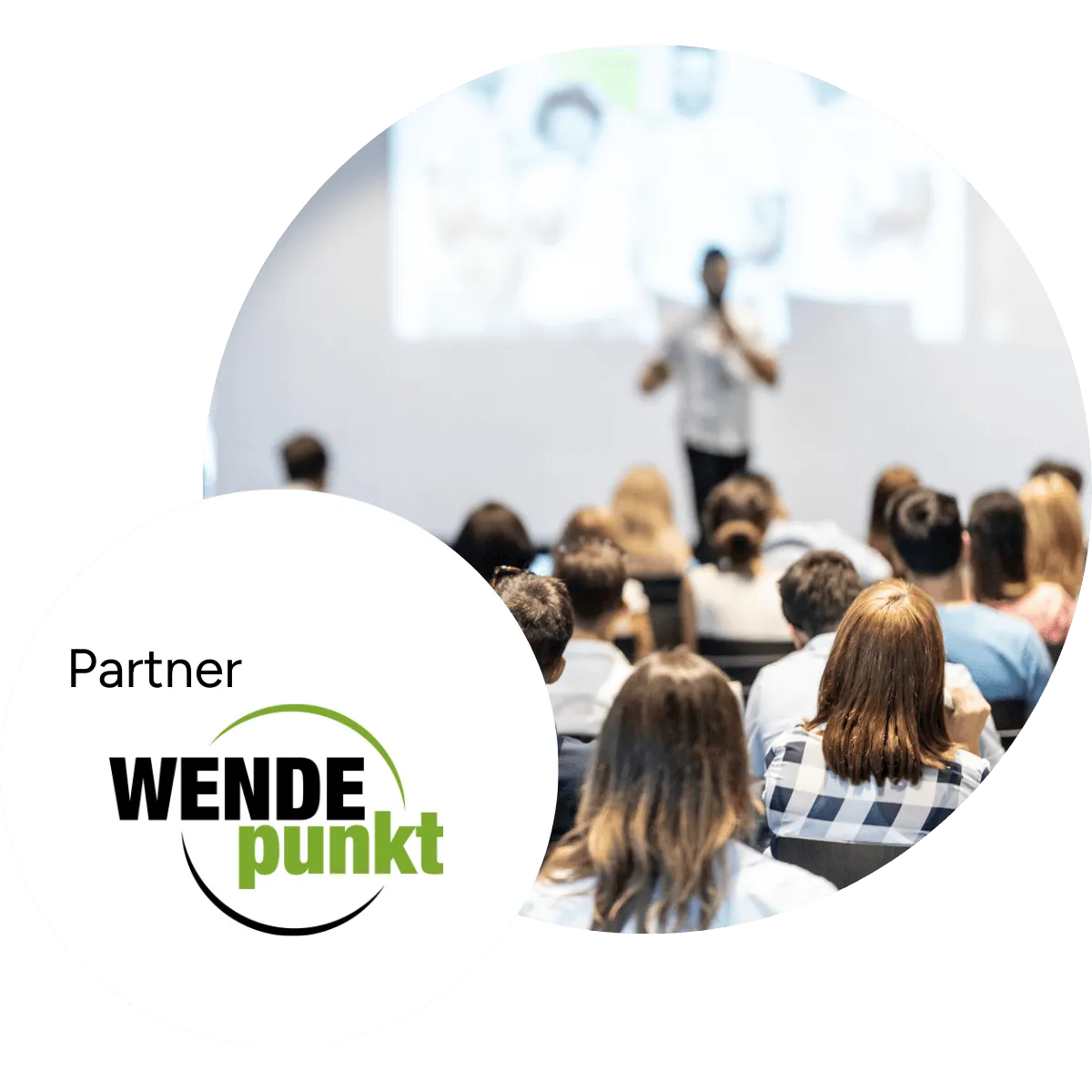 Publikum bei einem Vortrag, davor das Logo des Partners WENDEpunkt