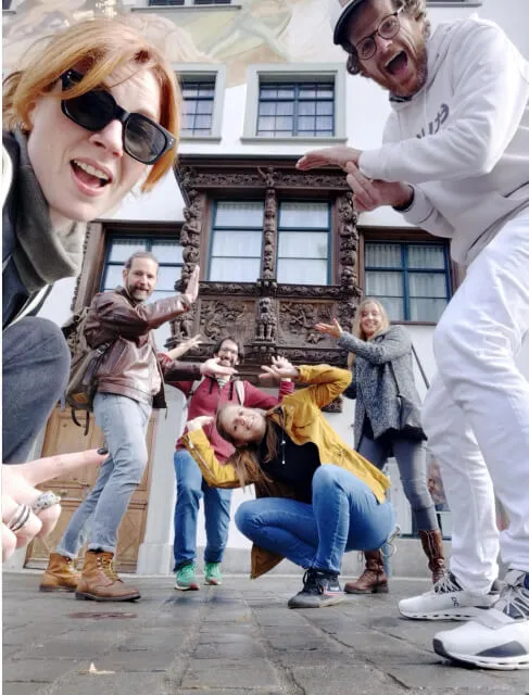 Das Eturnity-Team posiert ausgelassen vor einem historischen Haus mit geschnitzter Fassade