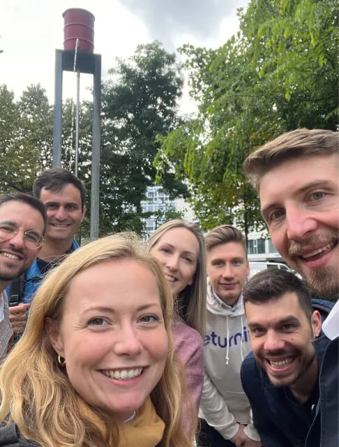 Acht Mitglieder des Eturnity-Teams machen im Park ein Gruppenselfie