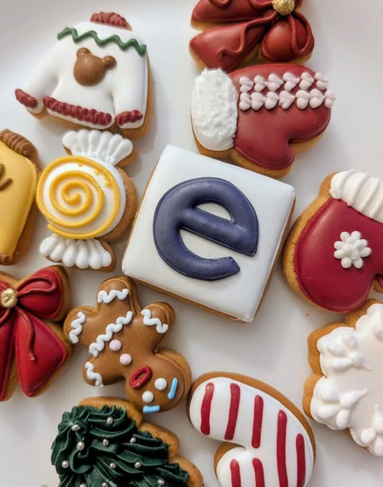 Decorated Christmas gingerbread cookies, one iced with the Eturnity "e" logo