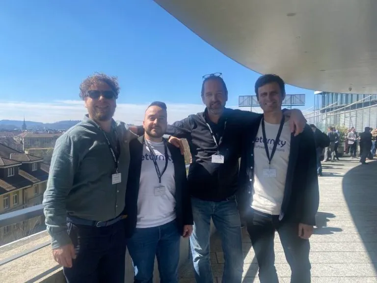 Vier Mitglieder des Eturnity-Teams auf einer sonnigen Dachterrasse