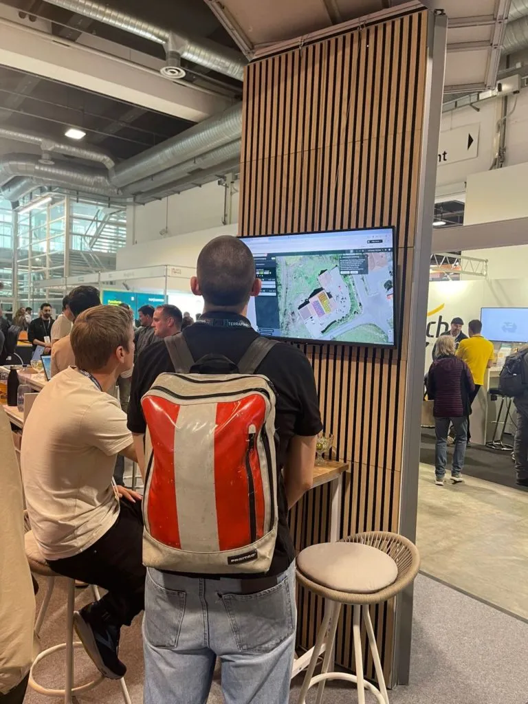 Gäste sehen an der Messe die Dachplanung von Eturnity auf einem Bildschirm