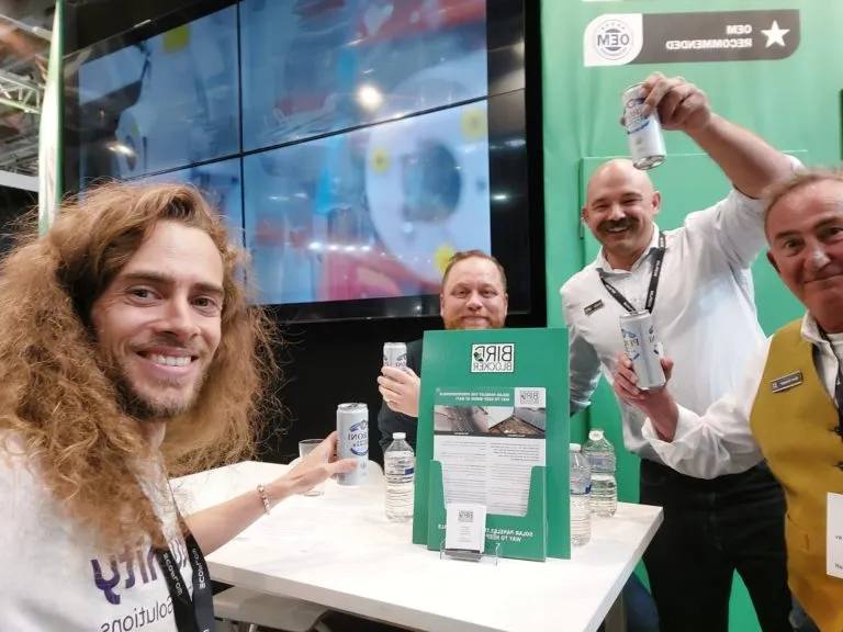 Eturnity-Team und Partner stoßen am Messestand miteinander an