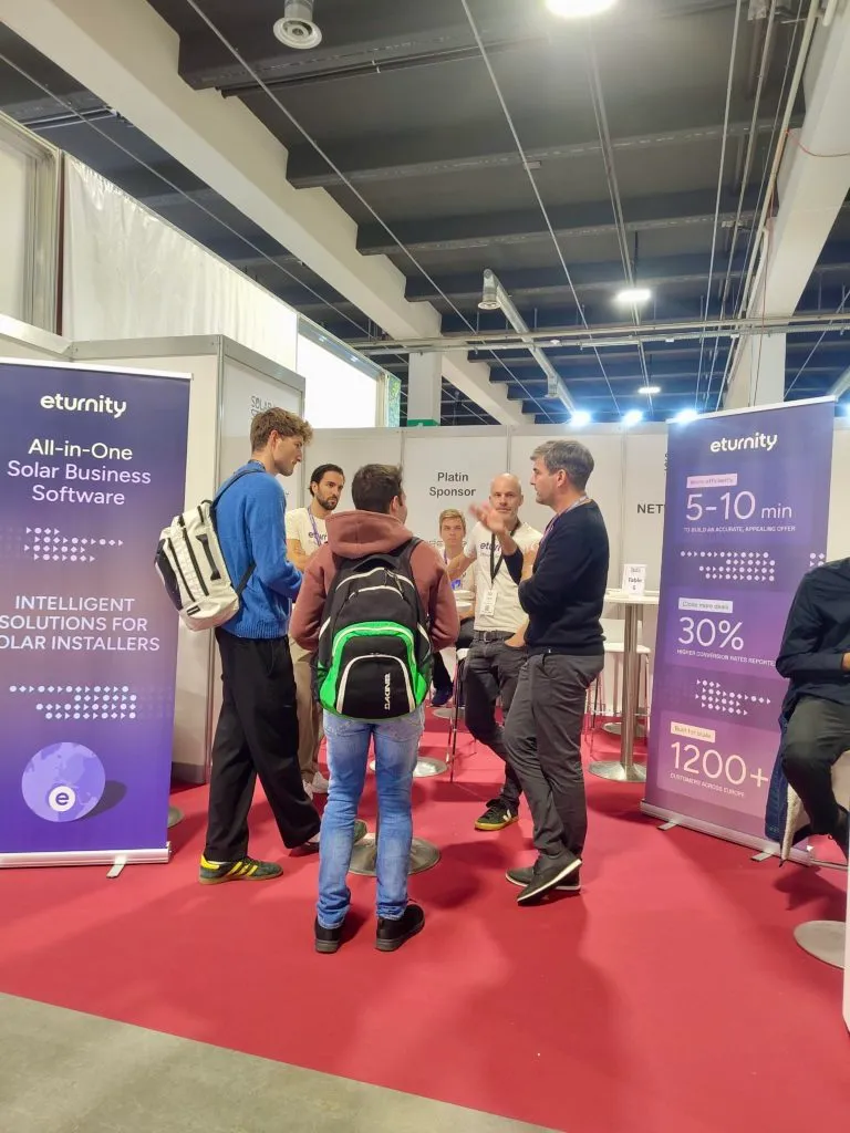Besucher sprechen am Eturnity-Stand zwischen Roll-ups über die Solarsoftware