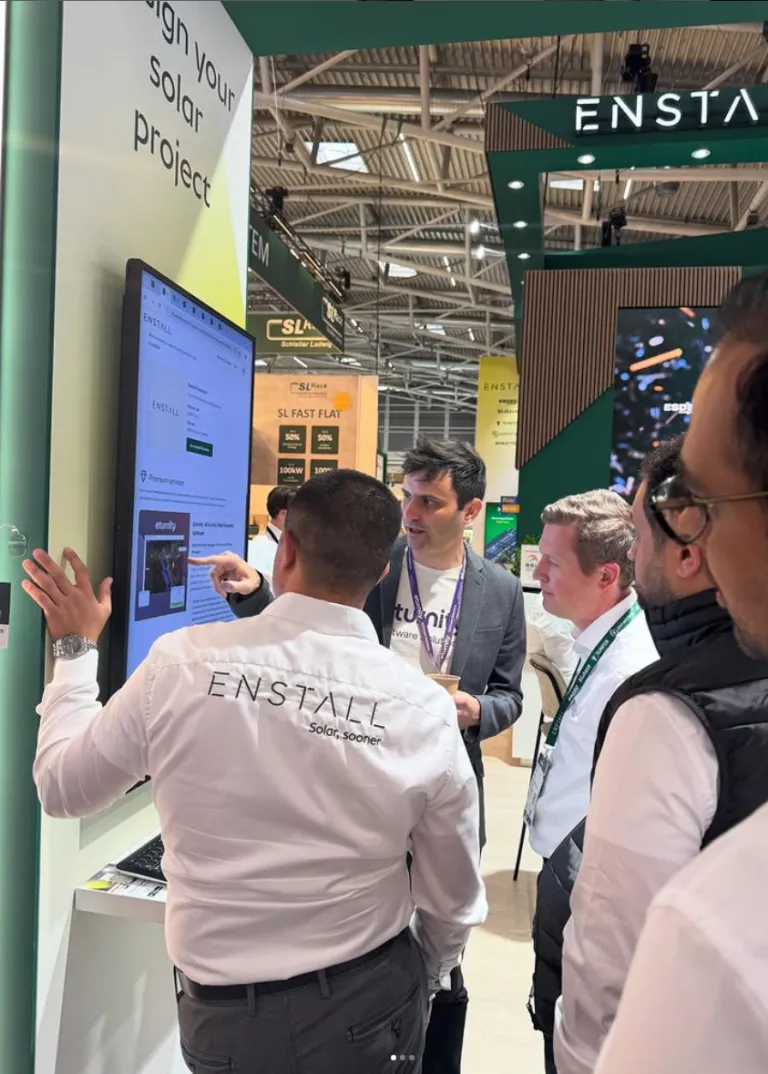 Visitors viewing an Eturnity software demo on a touchscreen at a trade-show booth