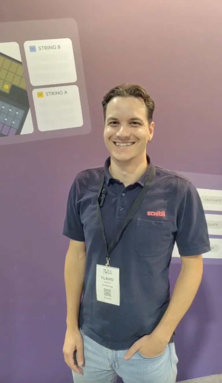 Lachender Eturnity-Mitarbeiter mit Lanyard am Messestand