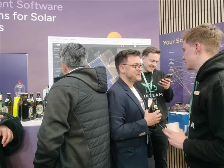 Gäste mit Getränken im Gespräch am Eturnity-Messestand