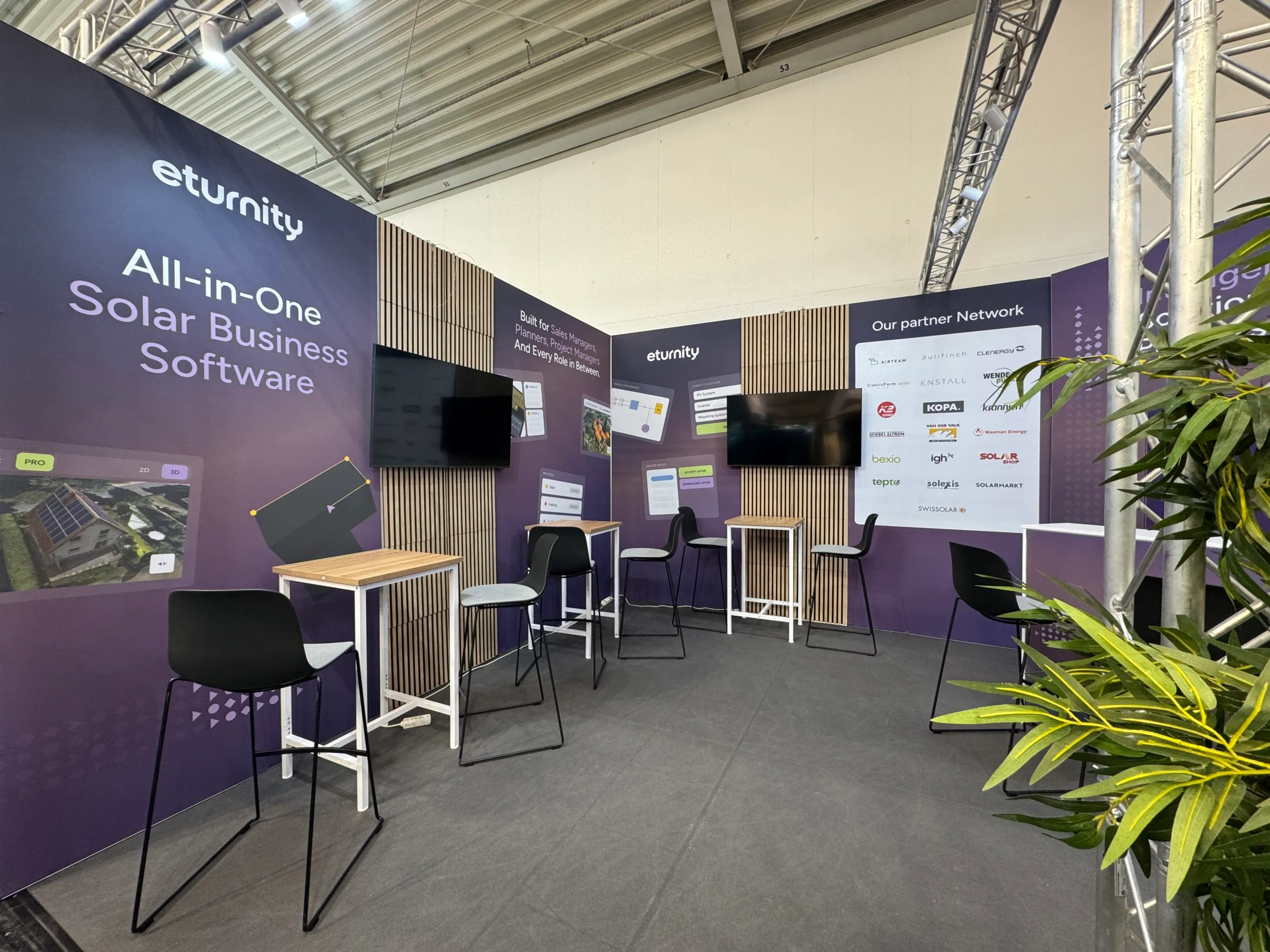Der Eturnity-Messestand mit Sitzgelegenheiten und Bildschirmen