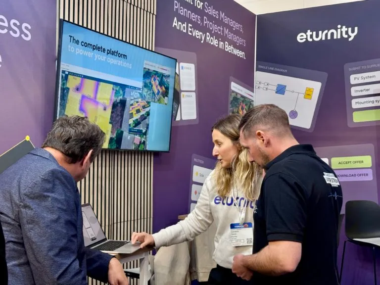 Eturnity-Mitarbeitende zeigen einem Besucher am Messestand die Software