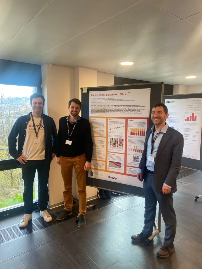 Drei Männer neben dem Studienposter „Photovoltaik Barometer 2025“ von Eturnity