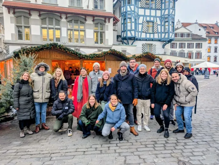 Das Eturnity-Team in Winterjacken vor einem Weihnachtsmarktstand in St. Gallen