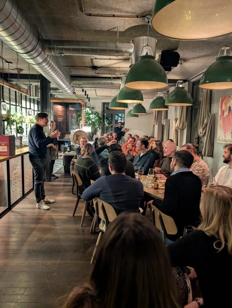 Ein Mann spricht stehend zum Eturnity-Team an einer langen Tafel in einem Restaurant