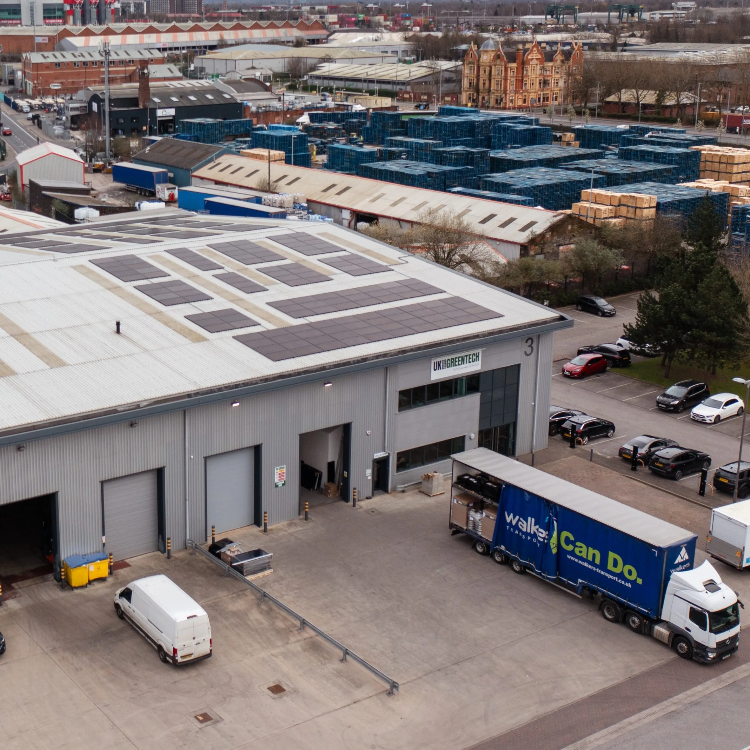 Vista aerea del magazzino di UK Greentech, con pannelli solari sul tetto e un camion in fase di carico davanti