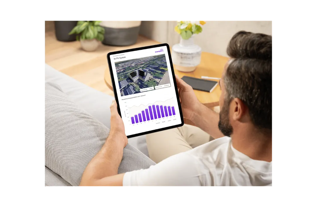 Ein Mann auf dem Sofa betrachtet auf dem Tablet sein PV-Angebot mit Monatsdiagramm