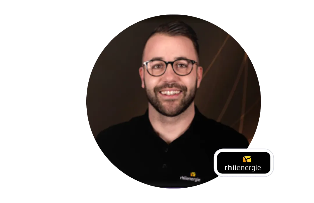 A smiling man with glasses in a rhiienergie shirt, next to the rhiienergie logo